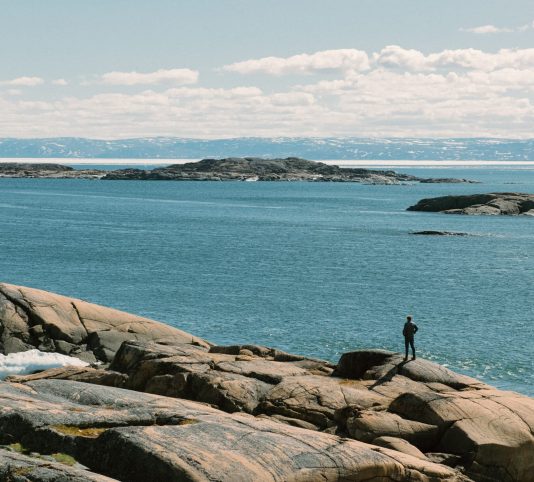 A man overlooks the inlet of Frobisher Bay from Sylvia Grinnel Territorial Park near Iqaluit, Nunavut, Canada. June 30, 2017